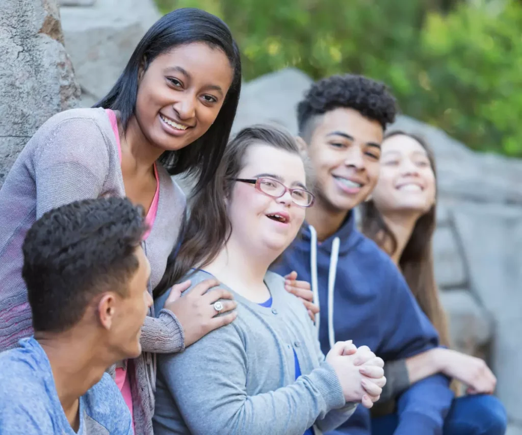 Disabled woman with down syndrome smiling happily with friends